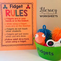 a green bowl filled with toys next to a sign that says fidgett rules