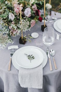 the table is set with white plates and silverware