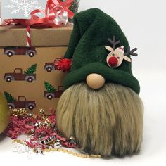 a green gnome hat sitting next to a christmas present