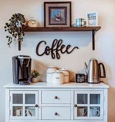 a white cabinet with some cups on top of it and a coffee maker above it