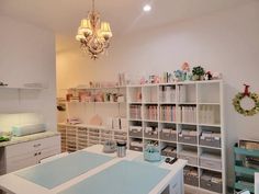 a room filled with lots of white shelves and drawers next to a chandelier