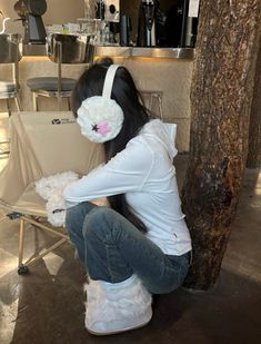 a woman sitting on a chair with her headphones up