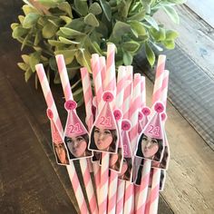 pink and white striped paper straws with pictures of two young women on them, one for the number twenty