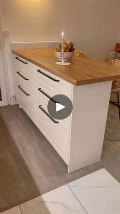 a kitchen with white cabinets and wooden counter tops