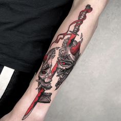 a person with a tattoo on their arm holding a knife and fork in his hand