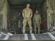 two men standing in the back of an aircraft