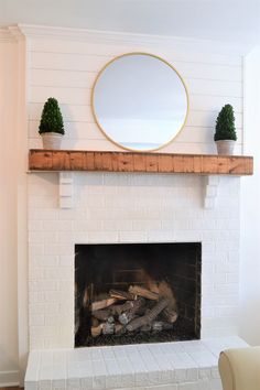 a fire place with a mirror above it