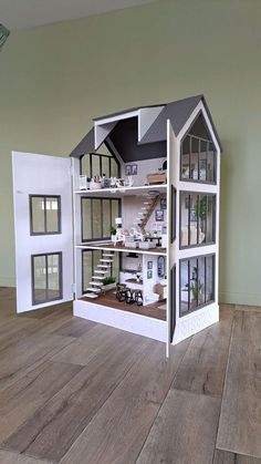 a doll house with all the furniture and accessories in it on a wooden flooring area