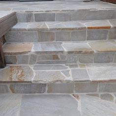 a wooden bench sitting on top of stone steps