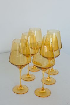 six yellow wine glasses sitting on top of each other