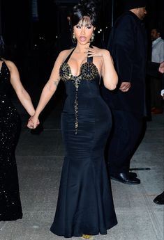 a woman in a black dress holding hands