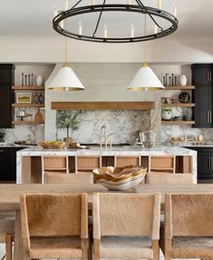 a modern kitchen with black cabinets and white marble countertops, an island in the center