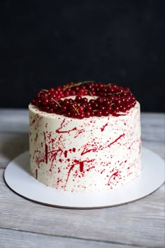 a white cake with red sprinkles on it sitting on top of a plate