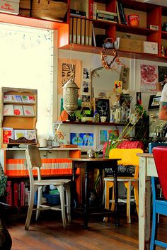 a man sitting at a table in a room filled with furniture and bookshelves