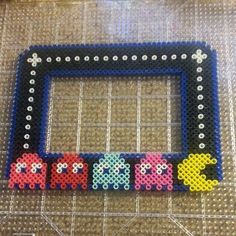 a photo frame made out of perler beads with the word pacman on it