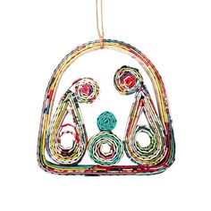 a colorful ornament hanging from a string on a white background with an image of two