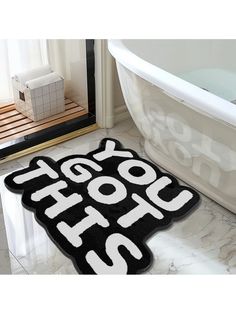 a black and white bathroom rug with the words look hot on it in front of a bathtub