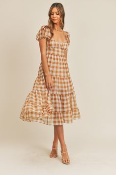 Short puff sleeves, gingham plaid midi-dress. Open back self tie. poly (also comes in dusty blue) Plaid Square Neck Dress For Garden Party, Square Neck Plaid Dress For Garden Party, Fitted Gingham Midi Dress With Ruffles, Chic Plaid Midi Dress, Summer Gingham Plaid Dress With Puff Sleeves, Fitted Gingham Midi Dress With Square Neck, Knee-length Ruffled Midi Dress For Picnic, Fall Gingham Plaid Midi Dress, Plaid Midi Dress For Picnic