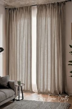 a living room with white curtains and a gray couch