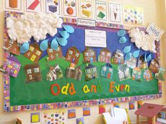 a bulletin board with houses and clouds on it in front of a classroom wall that says odddon's even