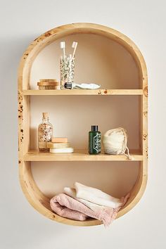 three shelves with different items on them in a bathroom or spa room, one shelf is made out of wood and the other has some sort of bamboo