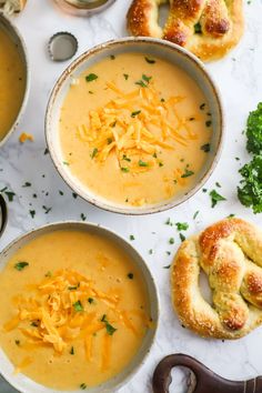 three bowls filled with soup and bread on top of a table