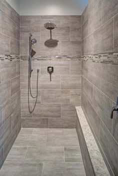 a walk in shower sitting next to a tiled wall and floor with two faucets on each side