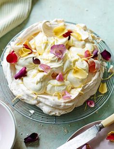 a cake with white frosting and colorful flowers on it next to a pair of scissors