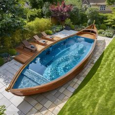 a small wooden boat sitting on top of a lush green field next to a swimming pool