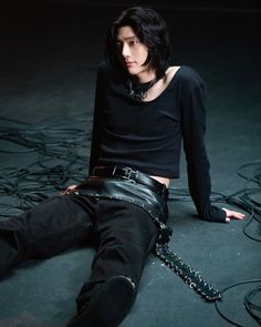 a person laying on the ground with chains around their ankles and wearing black clothing,