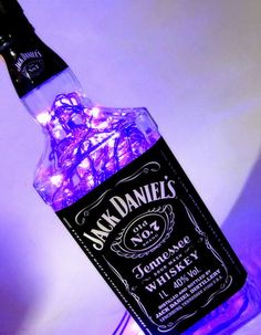 a bottle filled with purple lights sitting on top of a table