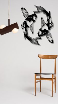 a chair sitting next to a lamp and a fish wall hanging on the side of a wall