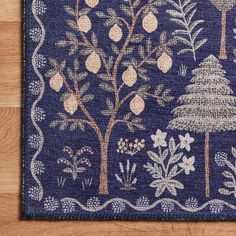 a blue rug with trees and pineapples on the front, along with other foliage