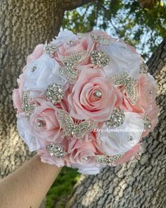 the bridal bouquet is made up of pink roses and diapered with crystals