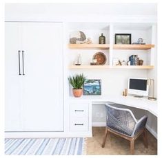 a home office with white cabinets and drawers