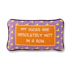 a purple and orange pillow with ducks on it that says, my quicks are absolutely not in a row