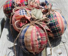 four plaid fabric pumpkins tied together on a wooden table with string and twine