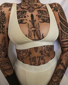 a woman with tattoos on her chest and arms