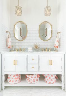 a bathroom with two sinks and mirrors on the wall next to it is decorated in pink polka dot pom poms