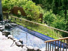 an outdoor hot tub surrounded by rocks and trees