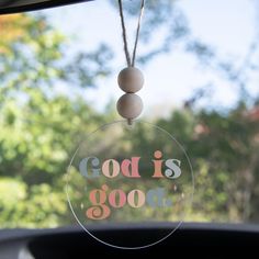 a glass ornament with the words god is good hanging from it's front window