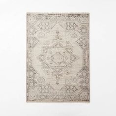 a beige rug with an intricate design on the bottom and sides, against a white wall