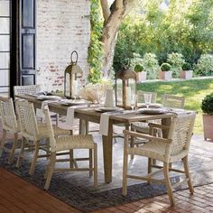 an outdoor dining table with chairs and place settings