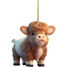 a brown and white cow ornament hanging from a gold colored chain on a white background