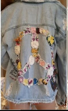 the back of a jean jacket with patches and flowers on it, along with an embroidered peace sign