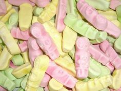 there are many different colored candies in the pile together and one is pink, green, yellow, and white