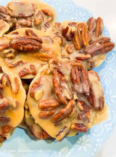 some pecans are covered in cheese and nuts on a blue plate with white flowers