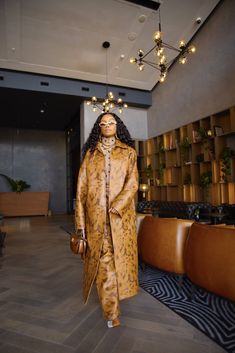 a mannequin dressed in an animal print coat and matching shoes stands on the floor