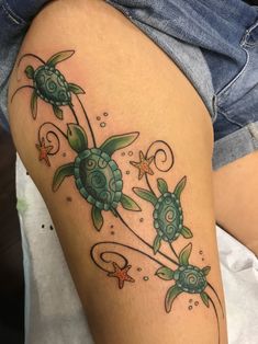 a woman's thigh with tattoos on her legs and turtle designs on the thighs