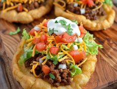 some taco pizzas are sitting on a cutting board